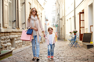 Image showing happy mother and child with shopping bags in city