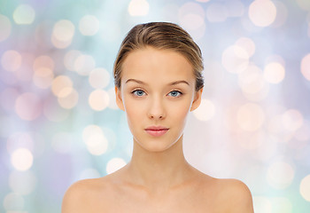 Image showing young woman face with bare shoulders over lights