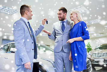 Image showing happy couple with car dealer in auto show or salon