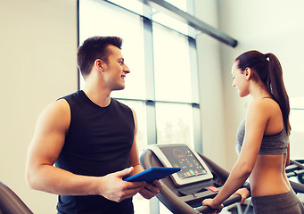 Image showing happy woman with trainer on treadmill in gym