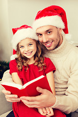 Image showing smiling father and daughter reading book