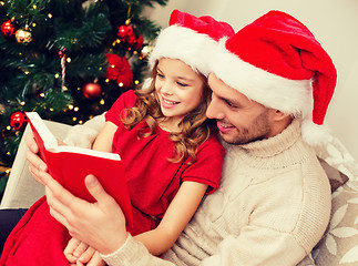 Image showing smiling father and daughter reading book