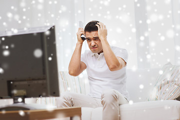 Image showing disappointed man watching tv at home