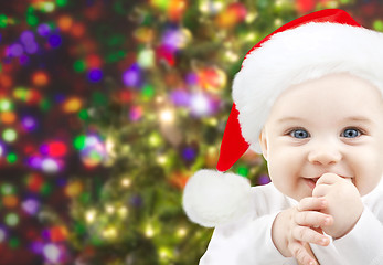 Image showing happy baby in santa hat over christmas lights