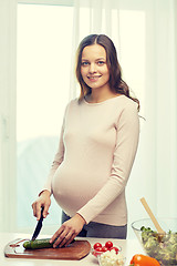 Image showing happy pregnant woman preparing food at home