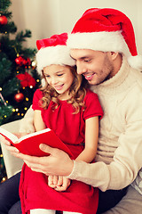 Image showing smiling father and daughter reading book