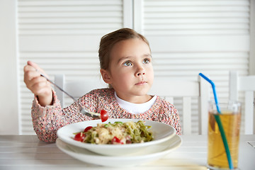 Image showing little girl eating pasta for dinner at restaurant