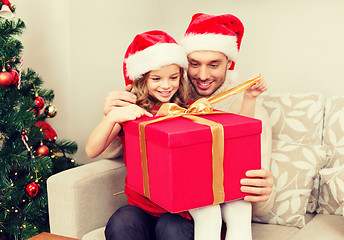 Image showing smiling father and daughter opening gift box