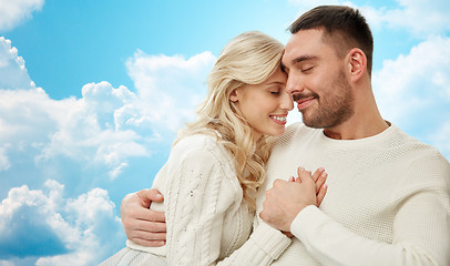 Image showing happy couple cuddling over blue sky and clouds