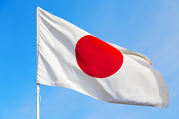 Image showing japanb waving flag in the blue sky  and wave