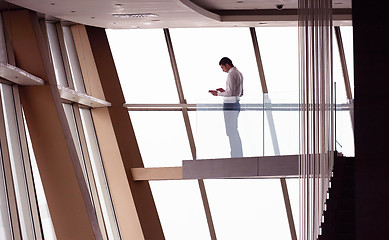 Image showing young successful business man in penthouse apartment working on 