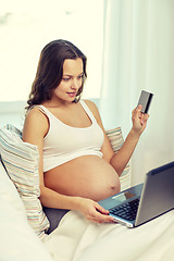 Image showing pregnant woman with laptop and credit card at home