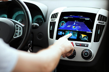 Image showing male hand using navigation system on car dashboard