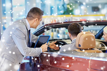 Image showing happy couple with car dealer in auto show or salon