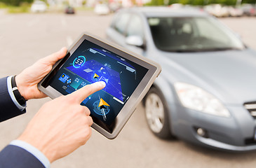 Image showing male hands with navigator on tablet pc and car