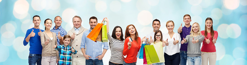 Image showing happy people with shopping bags showing thumbs up