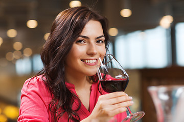 Image showing smiling woman drinking red wine at restaurant