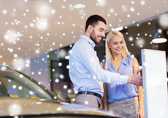 Image showing happy couple buying car in auto show or salon