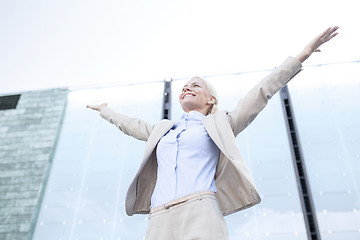 Image showing young smiling businesswoman over office building