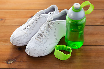 Image showing close up of sneakers, bracelet and water bottle