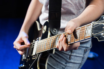 Image showing musician playing electric guitar with mediator