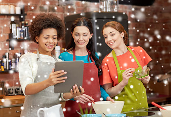 Image showing happy women with tablet pc cooking in kitchen