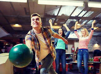 Image showing happy young man throwing ball in bowling club