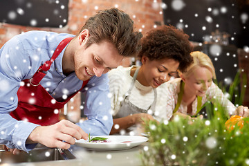 Image showing happy friends cooking and decorating dishes