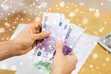 Image showing close up of man hands counting money at home