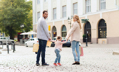 Image showing happy family with child and shopping bags in city