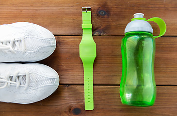 Image showing close up of sneakers, bracelet and water bottle