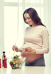 Image showing happy pregnant woman preparing food at home