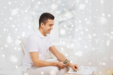 Image showing man with papers and calculator at home