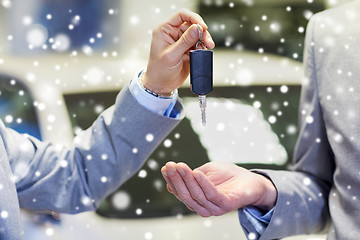 Image showing close up of male hands with car key in auto salon