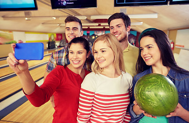 Image showing happy friends with smartphone in bowling club