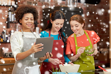 Image showing happy women with tablet pc cooking in kitchen