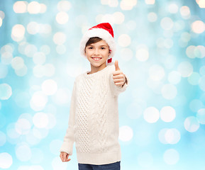 Image showing smiling happy boy in santa hat showing thumbs up