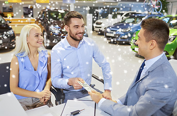 Image showing happy couple with money buying car from dealer