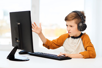 Image showing boy with computer and headphones at home