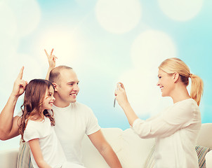 Image showing happy family with camera at home