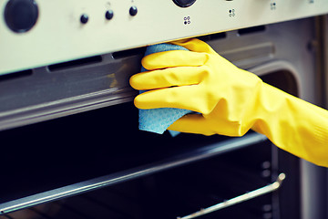 Image showing close up of woman cleaning oven at home kitchen