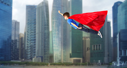 Image showing boy in red superhero cape and mask flying on air