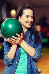 Image showing happy young woman holding ball in bowling club