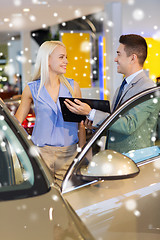 Image showing happy woman with car dealer in auto show or salon