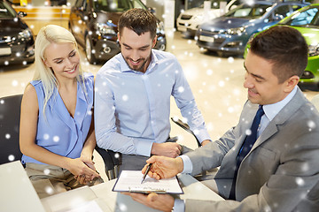 Image showing happy couple with car dealer in auto show or salon