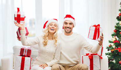 Image showing happy couple at home with christmas gift boxes