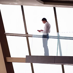 Image showing young successful business man in penthouse apartment working on 