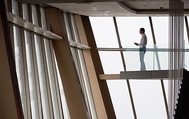 Image showing young successful business man in penthouse apartment working on 