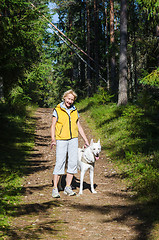 Image showing Woman with a dog on a walk in the park