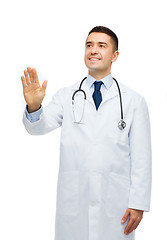 Image showing smiling male doctor touching something